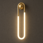 Cira brass wall light, switched on, with a warm glow
